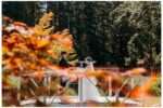 Bride and groom exchanging Vows on a bride on a sunny day with fall leaves